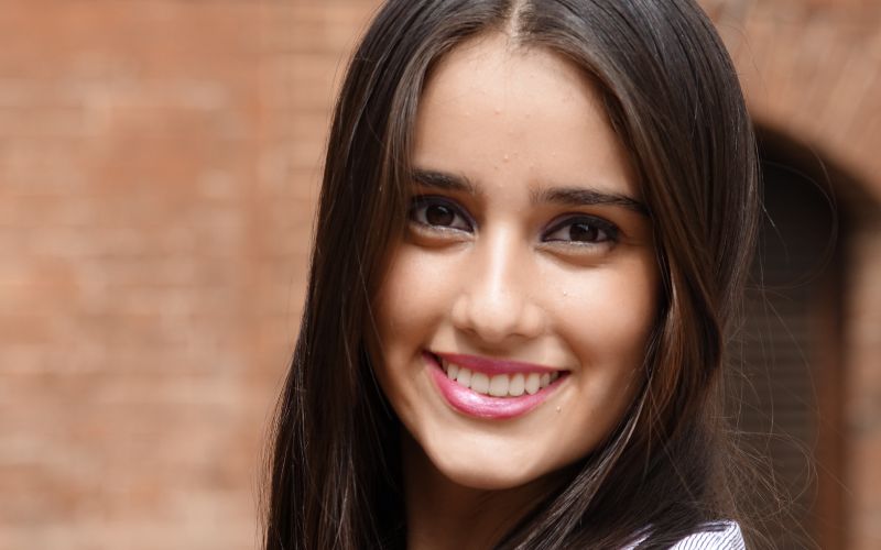 Smiling happy woman in front of wall