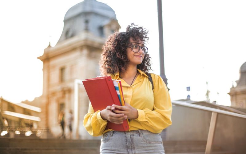 Woman walking with her books outside